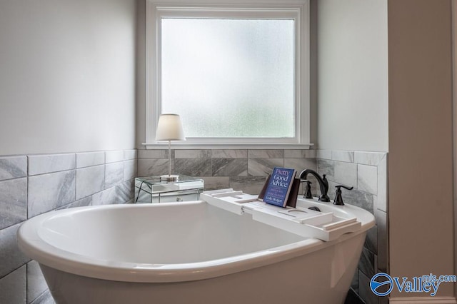 bathroom with tile walls and a washtub