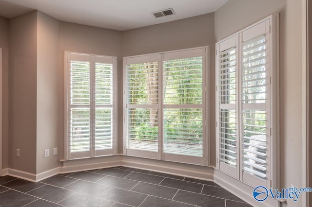 tiled spare room with a healthy amount of sunlight