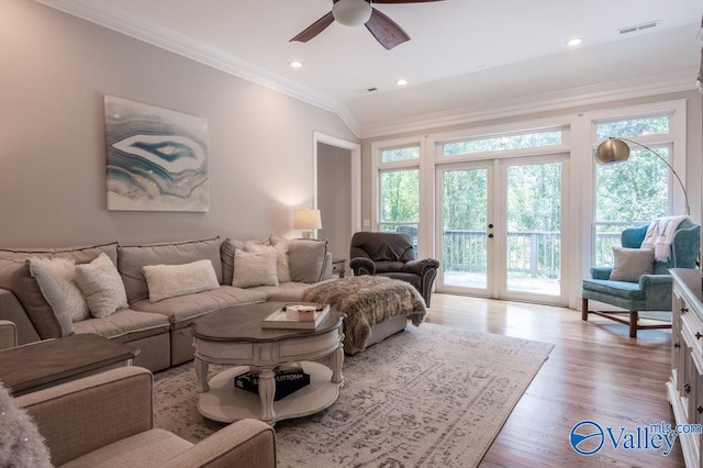 living room featuring light hardwood / wood-style floors, ceiling fan, plenty of natural light, and crown molding