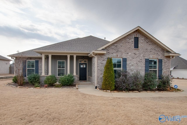 view of front of property with brick siding and a shingled roof