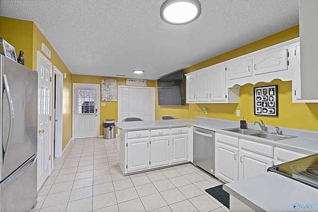 328 Shadow Pointe Dr SW, Decatur, AL 35601 - kitchen with stainless steel appliances, a peninsula, white cabinets, light tile patterned floors, and a textured ceiling