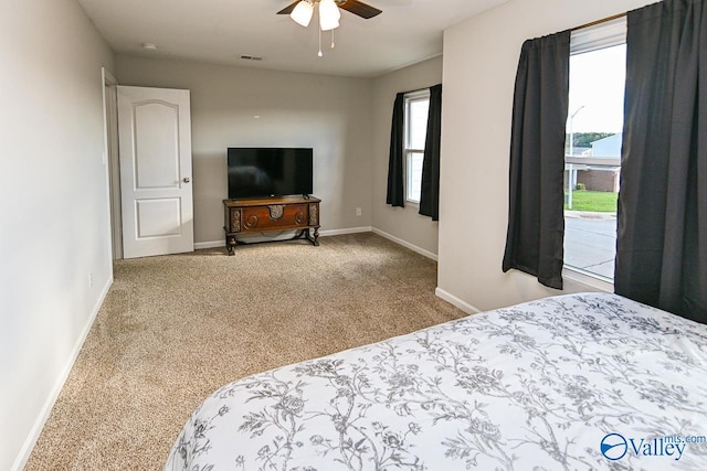 carpeted bedroom with ceiling fan and baseboards