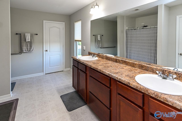 bathroom featuring double vanity, a sink, visible vents, and baseboards