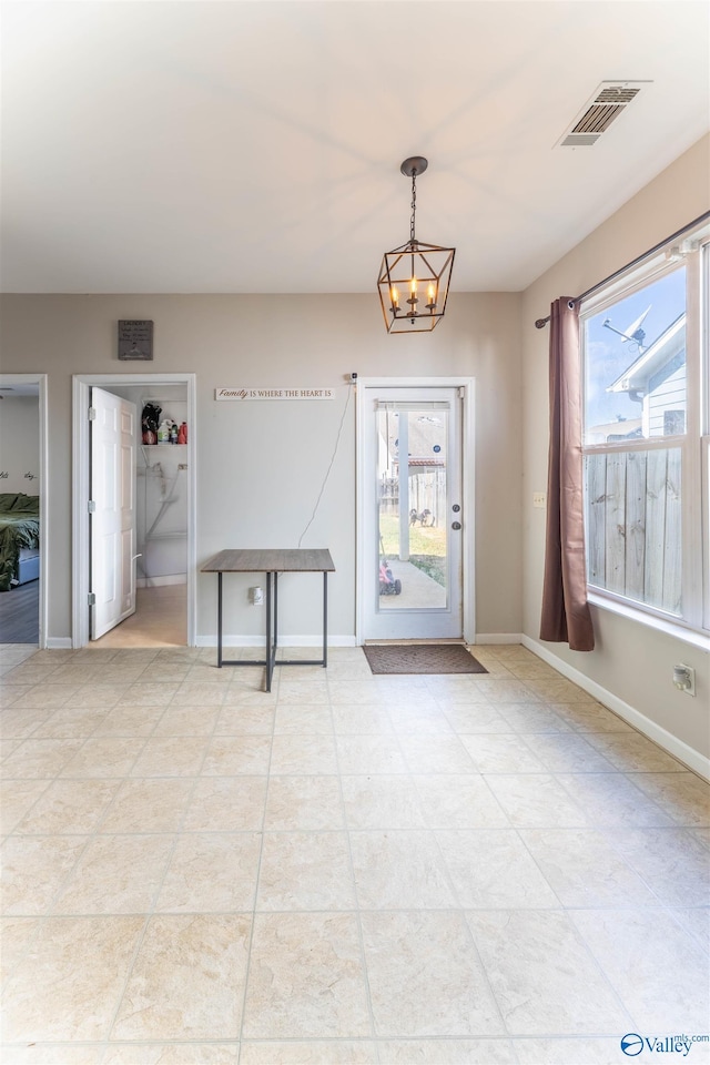 interior space featuring a chandelier, visible vents, and baseboards