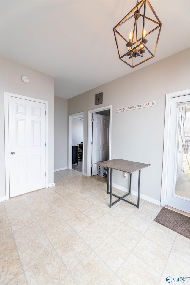 dining space featuring baseboards and a chandelier