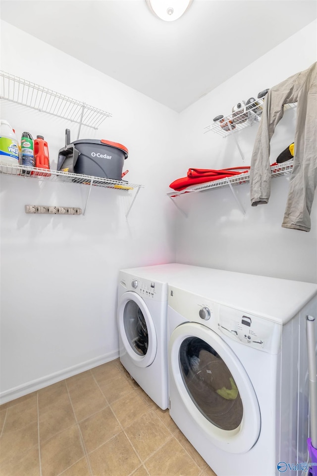 laundry room with laundry area, light tile patterned flooring, baseboards, and independent washer and dryer