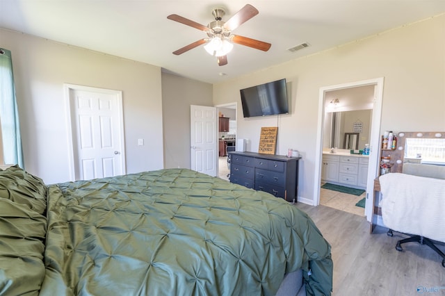 bedroom with ceiling fan, visible vents, light wood finished floors, and connected bathroom