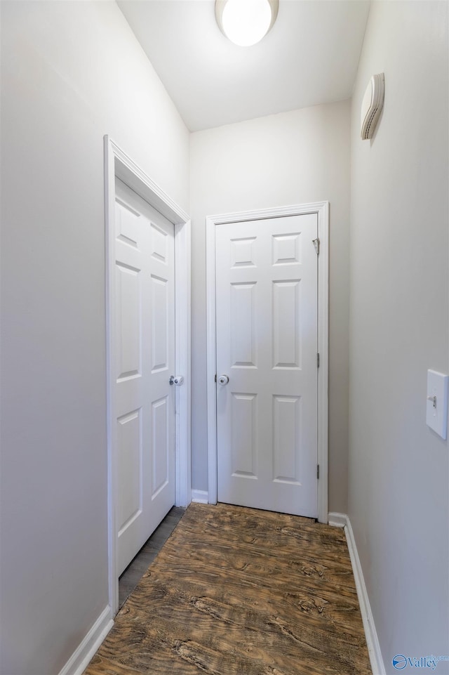 doorway with baseboards and dark wood-style floors