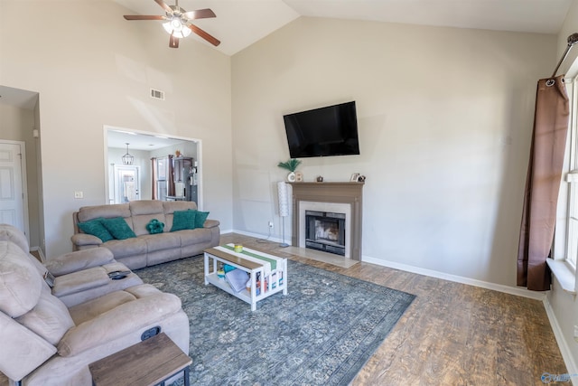 living area with wood finished floors, visible vents, baseboards, a fireplace, and ceiling fan