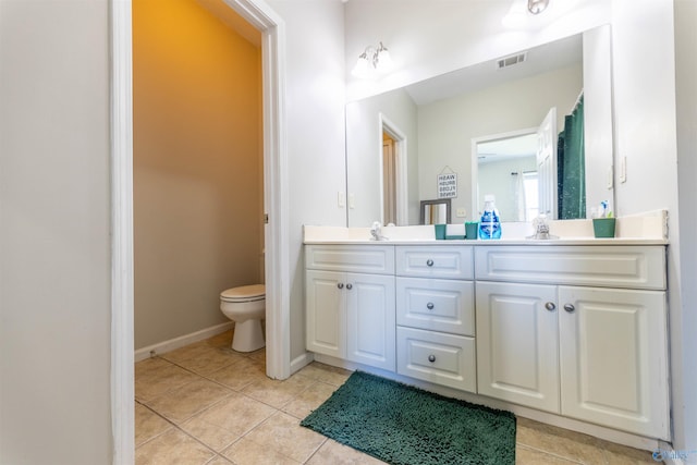 full bath with visible vents, double vanity, a sink, tile patterned flooring, and toilet