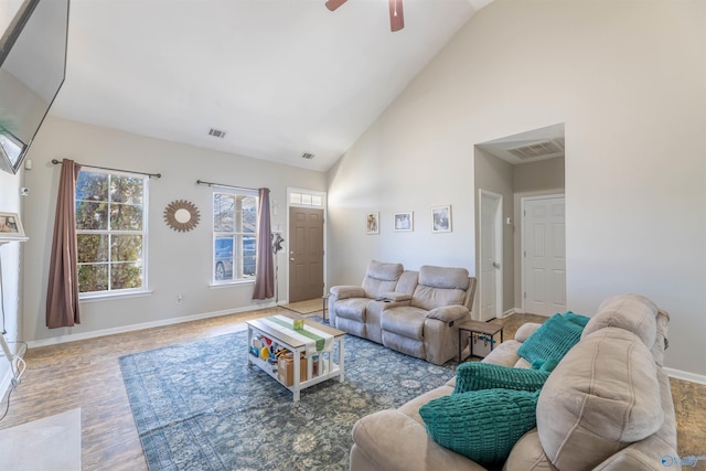 living area with visible vents, baseboards, high vaulted ceiling, and ceiling fan