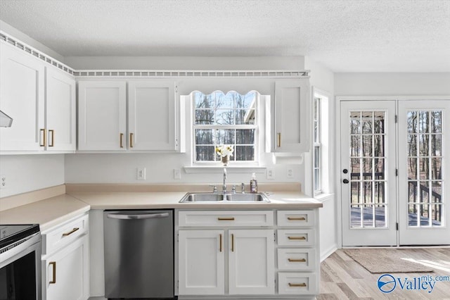 kitchen with white cabinetry, appliances with stainless steel finishes, sink, and a textured ceiling