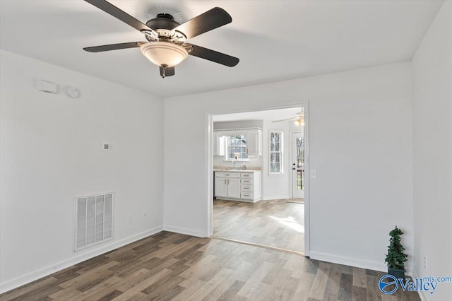 spare room with hardwood / wood-style floors and sink