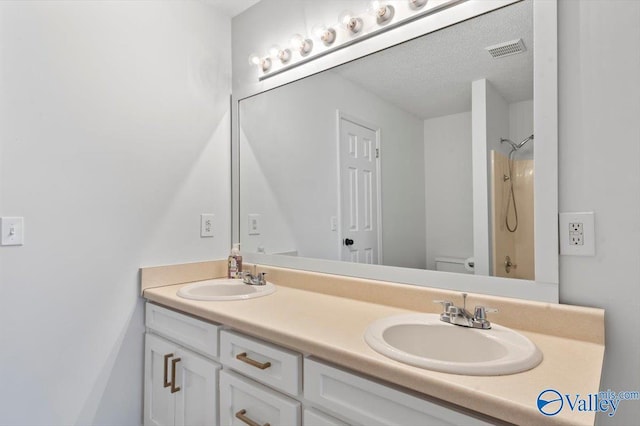 bathroom featuring vanity, a textured ceiling, and toilet