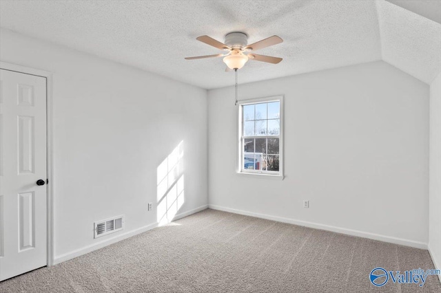 carpeted spare room featuring ceiling fan and a textured ceiling