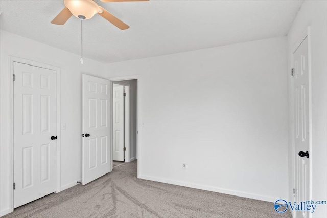 unfurnished bedroom featuring ceiling fan and carpet