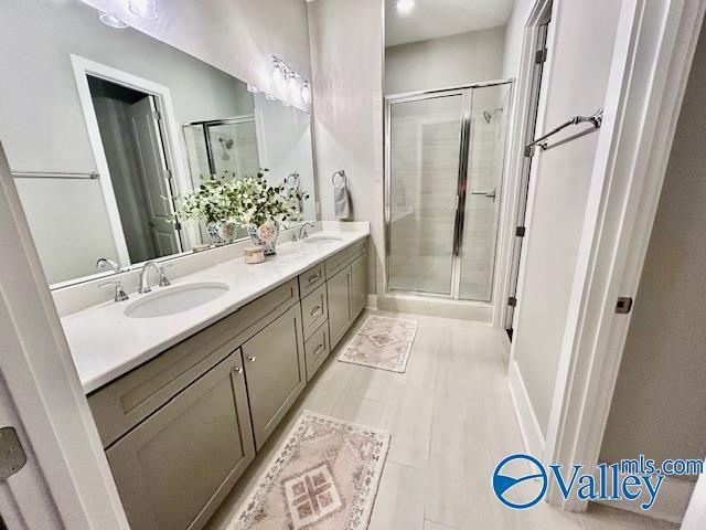 bathroom with vanity, a shower with shower door, and tile patterned flooring