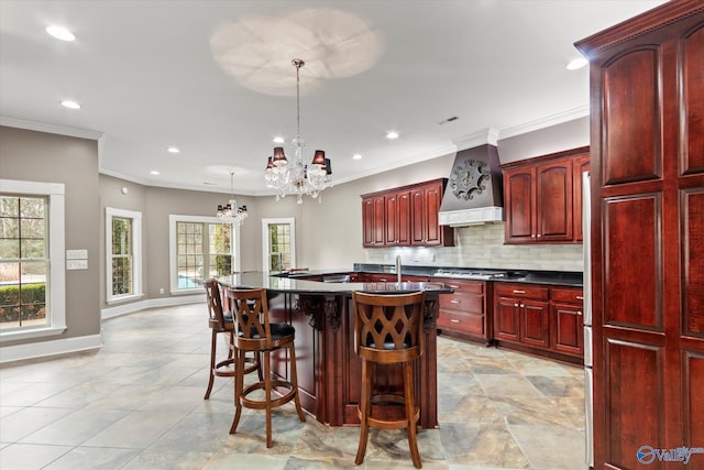 kitchen featuring pendant lighting, premium range hood, ornamental molding, a kitchen bar, and decorative backsplash