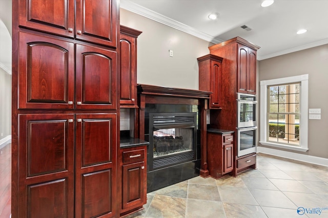 kitchen featuring ornamental molding, a fireplace, double oven, and light tile patterned floors