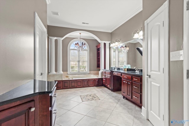 bathroom with tile patterned floors, ornamental molding, vanity, a bathtub, and decorative columns