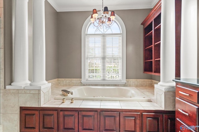 bathroom featuring a bath, a notable chandelier, ornamental molding, and decorative columns