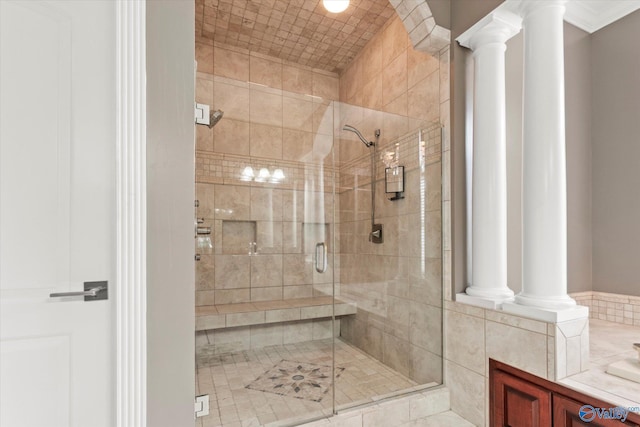 bathroom featuring decorative columns and an enclosed shower