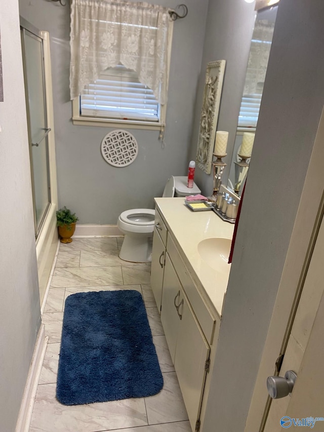 bathroom featuring vanity, marble finish floor, baseboards, and toilet