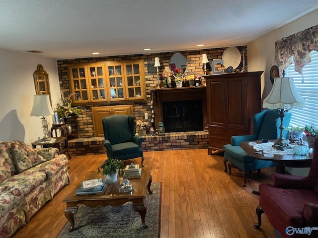 living room featuring light wood-type flooring and a fireplace