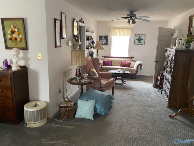 sitting room with visible vents, ceiling fan, carpet, and a textured ceiling