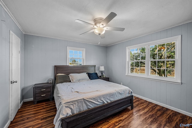 bedroom with crown molding, a ceiling fan, dark wood-type flooring, and baseboards