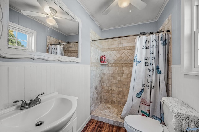 full bath with a tile shower, toilet, a ceiling fan, and a sink