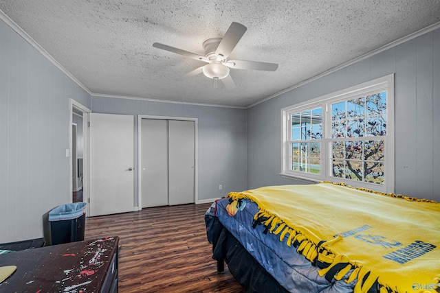 bedroom featuring a textured ceiling, wood finished floors, a closet, and ornamental molding