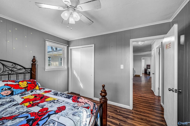 bedroom with ornamental molding, wood finished floors, a closet, baseboards, and ceiling fan