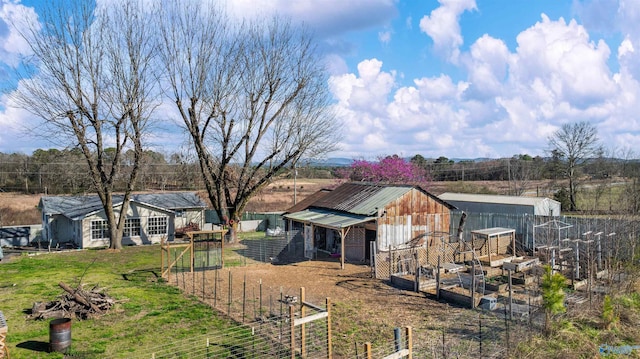 exterior space with a vegetable garden, an outdoor structure, and fence