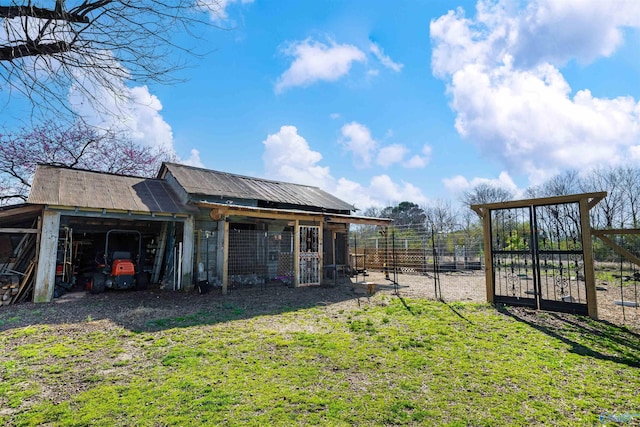 exterior space with an attached carport, an outbuilding, driveway, and fence