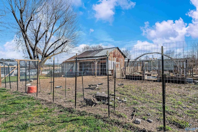 view of yard with fence, an outdoor structure, and a garden