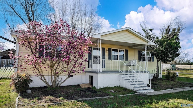 view of front of home featuring covered porch, stairs, and a front yard