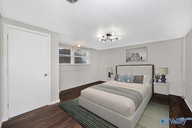 bedroom featuring a chandelier and dark wood-type flooring