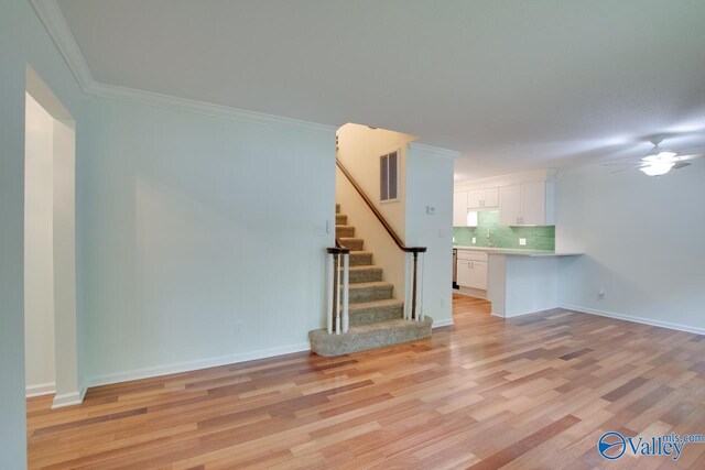 unfurnished room featuring crown molding, sink, ceiling fan, and light hardwood / wood-style flooring