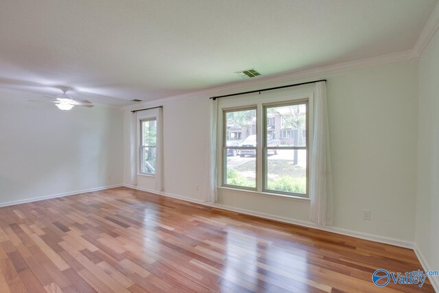 empty room with ornamental molding, ceiling fan, and light wood-type flooring