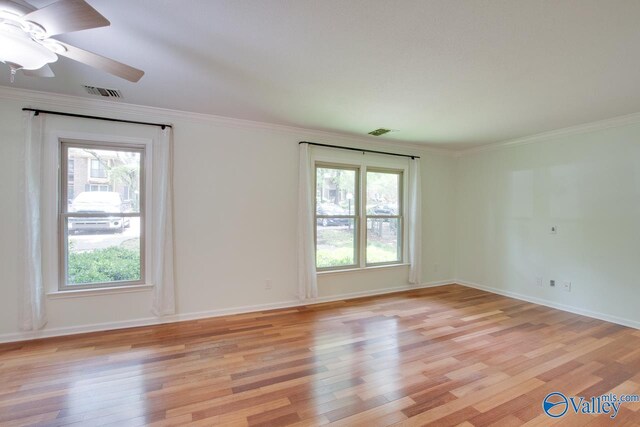 unfurnished room with light hardwood / wood-style flooring, a wealth of natural light, and ornamental molding