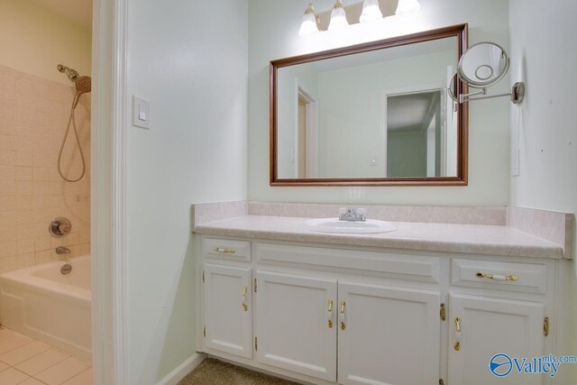 bathroom with tiled shower / bath combo, vanity, and tile patterned floors