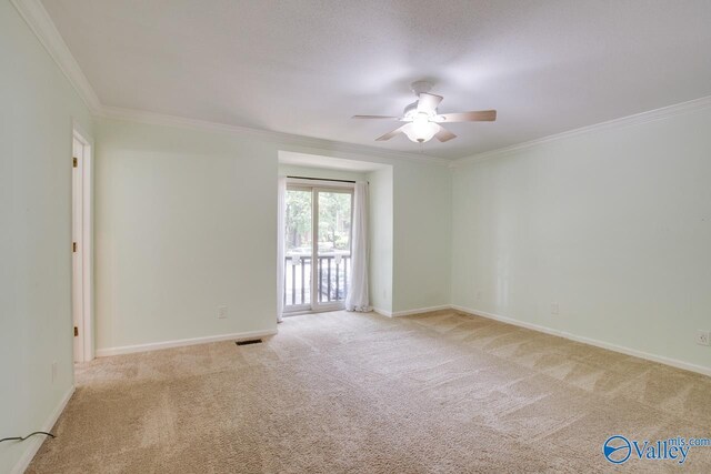 carpeted spare room featuring ornamental molding and ceiling fan