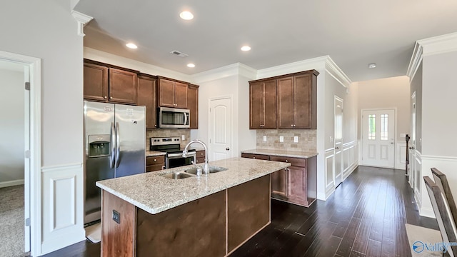 7607 NW Ashor Dr, Huntsville, AL 35806 - kitchen featuring appliances with stainless steel finishes, dark wood-type flooring, decorative backsplash, crown molding, and light stone counters