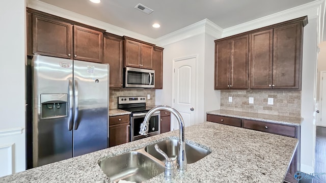 7607 NW Ashor Dr, Huntsville, AL 35806 - kitchen with stainless steel appliances, light stone counters, dark brown cabinetry, decorative backsplash, and ornamental molding