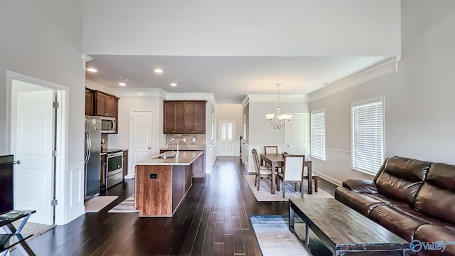 7607 NW Ashor Dr, Huntsville, AL 35806 - kitchen featuring stainless steel appliances, a chandelier, dark wood finished floors, a kitchen island with sink, and ornamental molding