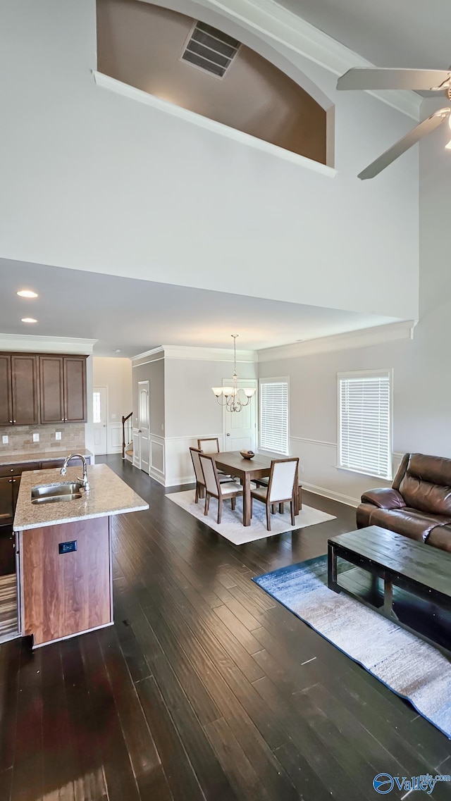 7607 NW Ashor Dr, Huntsville, AL 35806 - living area with high vaulted ceiling, a chandelier, dark wood finished floors, ornamental molding, and a ceiling fan