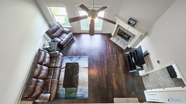 7607 NW Ashor Dr, Huntsville, AL 35806 - living area featuring ceiling fan, a towering ceiling, wood finished floors, and a fireplace with raised hearth