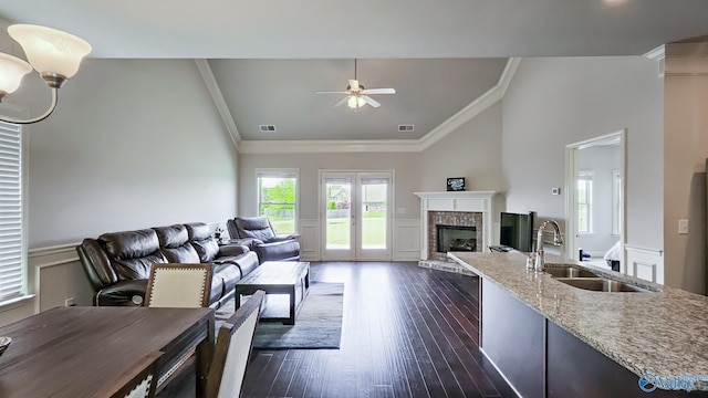 7607 NW Ashor Dr, Huntsville, AL 35806 - living room featuring crown molding, a ceiling fan, a brick fireplace, dark wood-style flooring, and wainscoting