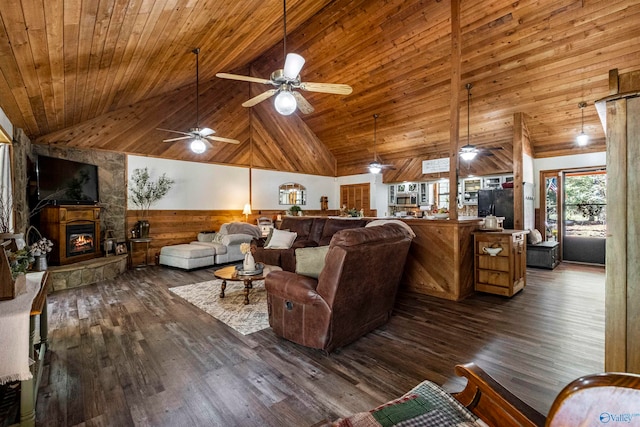 living room with ceiling fan, wooden walls, high vaulted ceiling, dark hardwood / wood-style floors, and a fireplace